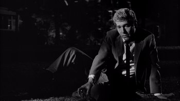 Movie still from “Who's Afraid of Virginia Woolf?” (1966), directed by Mike Nichols – A black and white photo of a man in a suit and tie; Medium shot, Low angle