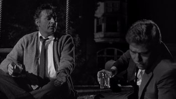 Movie still from “Who's Afraid of Virginia Woolf?” (1966), directed by Mike Nichols – Two men sitting on a bench one holding a glass of water; Medium shot, Low angle