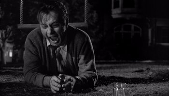 Movie still from “Who's Afraid of Virginia Woolf?” (1966), directed by Mike Nichols – A young man is laying on the ground with his mouth open; Medium shot, High angle