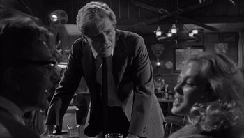 Movie still from “Who's Afraid of Virginia Woolf?” (1966), directed by Mike Nichols – A black and white photo of a man and a woman in a restaurant; Medium shot, Over the shoulder angle