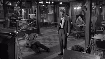 Movie still from “Who's Afraid of Virginia Woolf?” (1966), directed by Mike Nichols – A black and white photo of a man in a suit; Wide shot, High angle