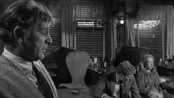 Movie still from “Who's Afraid of Virginia Woolf?” (1966), directed by Mike Nichols – Two men sitting at a table in front of a window; Medium shot, Over the shoulder angle