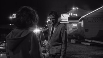 Movie still from “Who's Afraid of Virginia Woolf?” (1966), directed by Mike Nichols – A man and a woman standing in a parking lot at night; Medium shot, Over the shoulder angle
