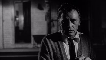 Movie still from “Who's Afraid of Virginia Woolf?” (1966), directed by Mike Nichols – A man wearing a sweater and a neck tie; Close Up shot, Low angle