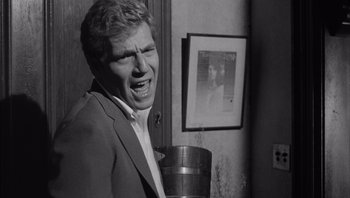 Movie still from “Who's Afraid of Virginia Woolf?” (1966), directed by Mike Nichols – A black and white photo of a man in a suit; Close Up shot, Over the shoulder angle