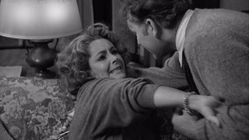 Movie still from “Who's Afraid of Virginia Woolf?” (1966), directed by Mike Nichols – A woman laying on the ground with a man on her lap; Medium shot, Over the shoulder angle