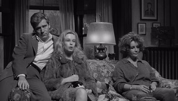 Movie still from “Who's Afraid of Virginia Woolf?” (1966), directed by Mike Nichols – A black - and - white photo of three people sitting on a couch; Medium shot, High angle