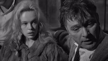 Movie still from “Who's Afraid of Virginia Woolf?” (1966), directed by Mike Nichols – A man and a woman sitting next to each other on a couch; Close Up shot, Over the shoulder angle