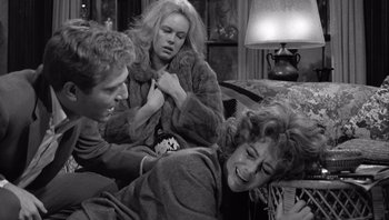 Movie still from “Who's Afraid of Virginia Woolf?” (1966), directed by Mike Nichols – A group of people sitting on a couch; Medium shot, Over the shoulder angle