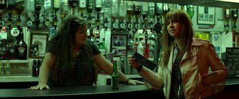 Movie still from “Wild Rose” (2018), directed by Tom Harper – Two women are at a bar and one of them is holding a beer; Medium shot, Over the shoulder angle
