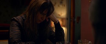 Movie still from “Wild Rose” (2018), directed by Tom Harper – A woman sitting at a table with her head resting on her hand; Close Up shot, High angle