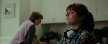 Movie still from “Wild Rose” (2018), directed by Tom Harper – A woman wearing headphones looking up at the ceiling; Close Up shot, Over the shoulder angle