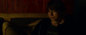 Movie still from “Wild Rose” (2018), directed by Tom Harper – A young man sitting in a chair in a dark room; Close Up shot, Over the shoulder angle