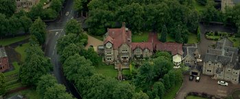Movie still from “Wild Rose” (2018), directed by Tom Harper – An aerial view of a large house surrounded by trees; Extreme Wide shot, High angle