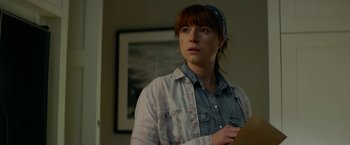 Movie still from “Wild Rose” (2018), directed by Tom Harper – A woman standing in front of a wall with a picture on the wall; Close Up shot, Over the shoulder angle