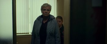 Movie still from “Wild Rose” (2018), directed by Tom Harper – An older woman standing next to a young girl; Medium shot, Low angle