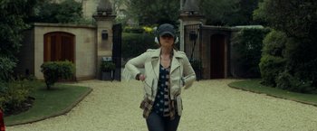 Movie still from “Wild Rose” (2018), directed by Tom Harper – A woman wearing a white jacket and headphones; Wide shot, Over the shoulder angle