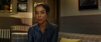 Movie still from “Wild Rose” (2018), directed by Tom Harper – A woman sitting on a couch in front of a window; Close Up shot, Over the shoulder angle