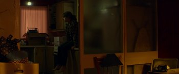 Movie still from “Wild Rose” (2018), directed by Tom Harper – A person sitting on a chair in a room; Wide shot, High angle