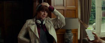 Movie still from “Wild Rose” (2018), directed by Tom Harper – A woman in a leather jacket with headphones on her head; Close Up shot, Over the shoulder angle