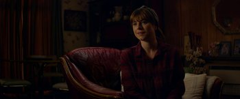 Movie still from “Wild Rose” (2018), directed by Tom Harper – A woman sitting in a chair in the dark; Medium shot, Over the shoulder angle