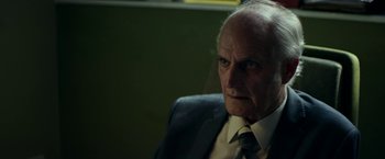 Movie still from “Wild Rose” (2018), directed by Tom Harper – An older man wearing a suit and tie; Close Up shot, Over the shoulder angle