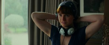 Movie still from “Wild Rose” (2018), directed by Tom Harper – A woman wearing headphones posing for a picture; Close Up shot, Low angle