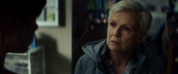 Movie still from “Wild Rose” (2018), directed by Tom Harper – An older woman in a blue jacket looks at the camera; Close Up shot, Over the shoulder angle
