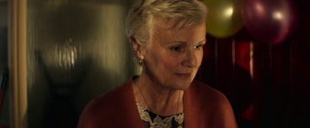 Movie still from “Wild Rose” (2018), directed by Tom Harper – An older woman with short blonde hair looking at the camera; Close Up shot, Over the shoulder angle
