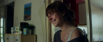 Movie still from “Wild Rose” (2018), directed by Tom Harper – A woman smiling and looking to her left; Close Up shot, Over the shoulder angle