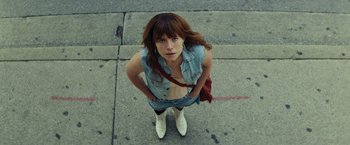 Movie still from “Wild Rose” (2018), directed by Tom Harper – A woman standing on the sidewalk with her hands on her hips; Close Up shot, Overhead angle