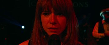 Movie still from “Wild Rose” (2018), directed by Tom Harper – A person with a microphone; Close Up shot, High angle