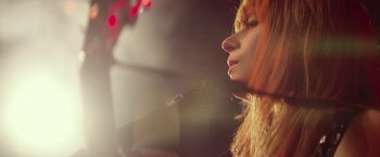 Movie still from “Wild Rose” (2018), directed by Tom Harper – A person holding a microphone; Close Up shot, Low angle