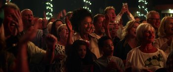Movie still from “Wild Rose” (2018), directed by Tom Harper – A group of people standing in front of a crowd; Medium shot, Low angle