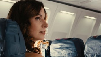 Movie still from “Wild Tales” (2014), directed by Damián Szifron – A woman sitting on a seat on an airplane looking into the distance; Close Up shot, Low angle