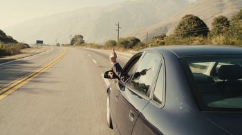 Movie still from “Wild Tales” (2014), directed by Damián Szifron – A man in a suit is sticking his arm out of a car window; Wide shot, Low angle
