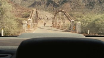 Movie still from “Wild Tales” (2014), directed by Damián Szifron – A person walking across a bridge over a river; Extreme Wide shot, Over the shoulder angle