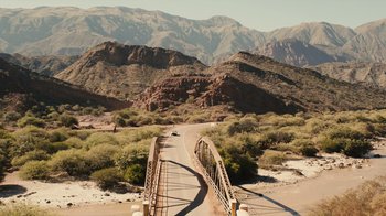 Movie still from “Wild Tales” (2014), directed by Damián Szifron – A car is driving on a bridge in the desert; Extreme Wide shot, High angle