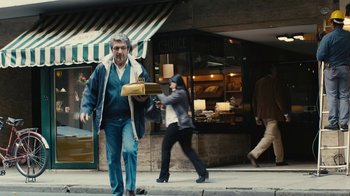 Movie still from “Wild Tales” (2014), directed by Damián Szifron – A man walking down the street while holding a box; Wide shot, Over the shoulder angle