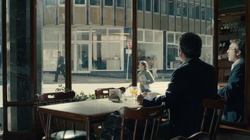 Movie still from “Wild Tales” (2014), directed by Damián Szifron – A man sitting at a table in front of a store window; Wide shot, Over the shoulder angle