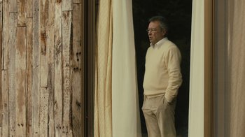 Movie still from “Wild Tales” (2014), directed by Damián Szifron – An older man standing in front of a window; Medium shot, Low angle