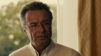Movie still from “Wild Tales” (2014), directed by Damián Szifron – An older man wearing a white shirt and a white sweater; Close Up shot, Over the shoulder angle