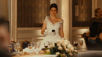Movie still from “Wild Tales” (2014), directed by Damián Szifron – A woman in a white dress holding a cell phone; Medium shot, Over the shoulder angle
