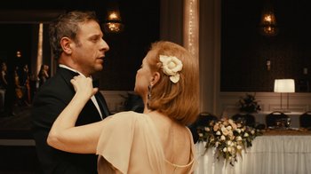 Movie still from “Wild Tales” (2014), directed by Damián Szifron – A man and a woman in formal wear standing next to each other in front of flowers; Close Up shot, Over the shoulder angle