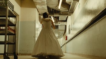 Movie still from “Wild Tales” (2014), directed by Damián Szifron – A woman in a long white dress walking down a hallway; Wide shot, Low angle