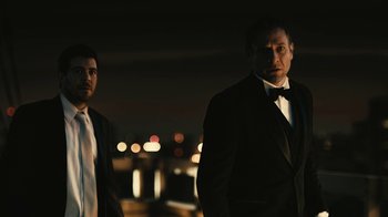 Movie still from “Wild Tales” (2014), directed by Damián Szifron – A man in a suit standing next to another man in a suit; Medium shot, Low angle
