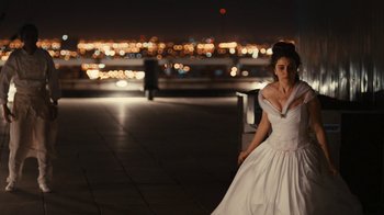 Movie still from “Wild Tales” (2014), directed by Damián Szifron – A woman in a white dress is sitting on a bench; Wide shot, Over the shoulder angle