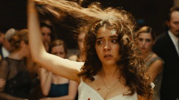 Movie still from “Wild Tales” (2014), directed by Damián Szifron – A woman with long brown hair in front of a group of people; Close Up shot, Over the shoulder angle