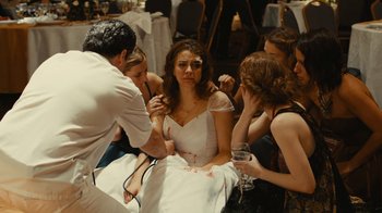 Movie still from “Wild Tales” (2014), directed by Damián Szifron – A group of people gathered around a woman in a white dress; Medium shot, High angle