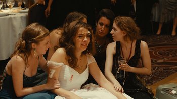 Movie still from “Wild Tales” (2014), directed by Damián Szifron – A group of women sitting around a woman in a wedding dress; Medium shot, High angle